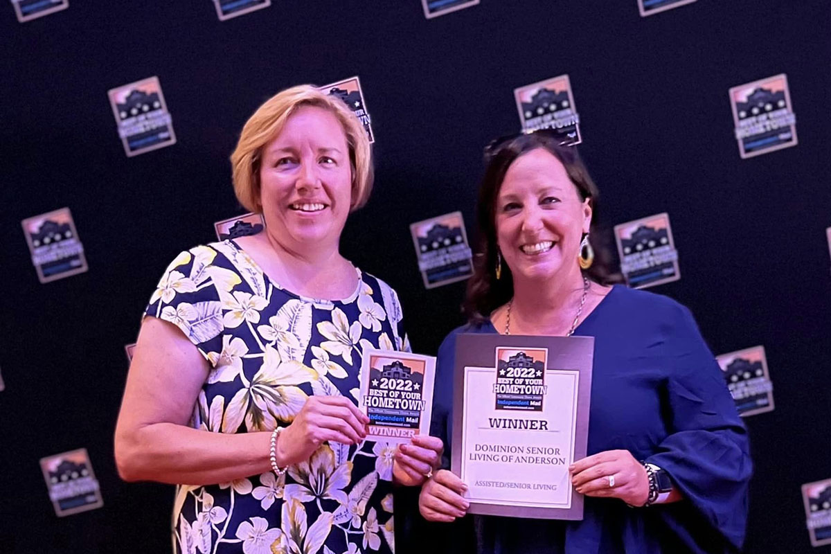 Dominion of Anderson | Two women holding a plaque for the Best of Your HomeTown Assisted Living Award