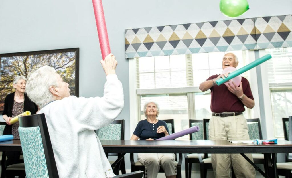 Dominion of Bristol | Seniors participating in games and activities with balloons and pool noodles
