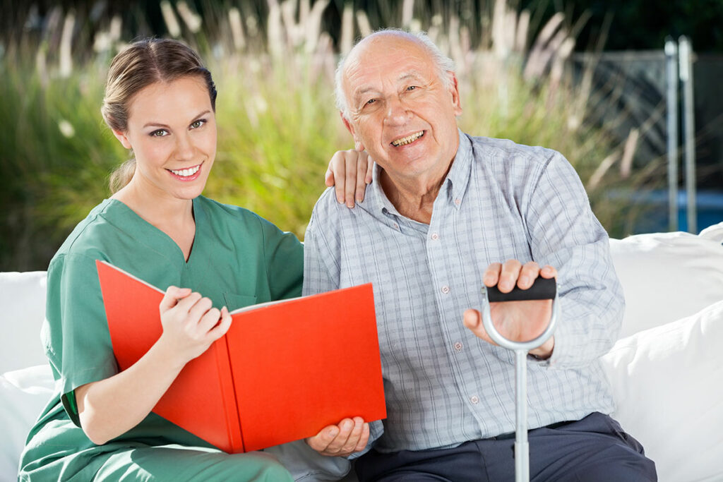 Dominion of Frankfort | Senior man looking at photo album with caregiver