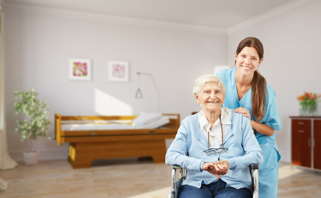 Dominion of Frankfort | Senior woman in a wheelchair smiling next to her caregiver