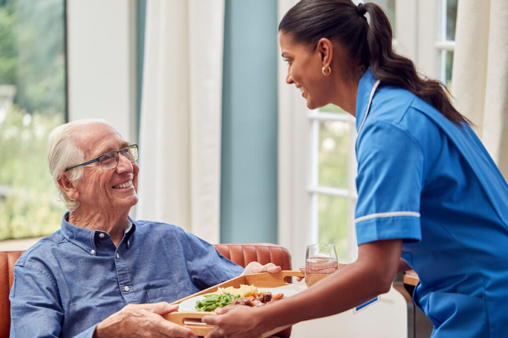 Dominion of Louisville | Senior man being served a meal by his caregiver