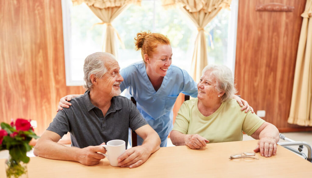 Dominion of Louisville | Senior couple sitting while talking to their caregiver behind them