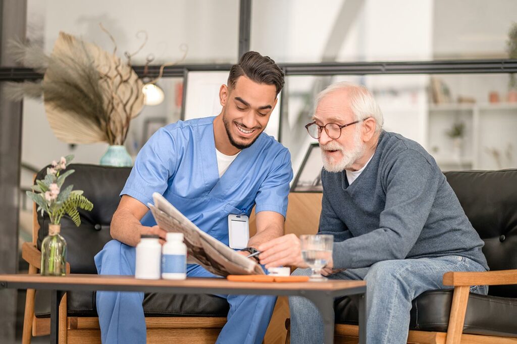 Dominion of Louisville | Senior with caregiver doing crossword puzzle in newspaper together