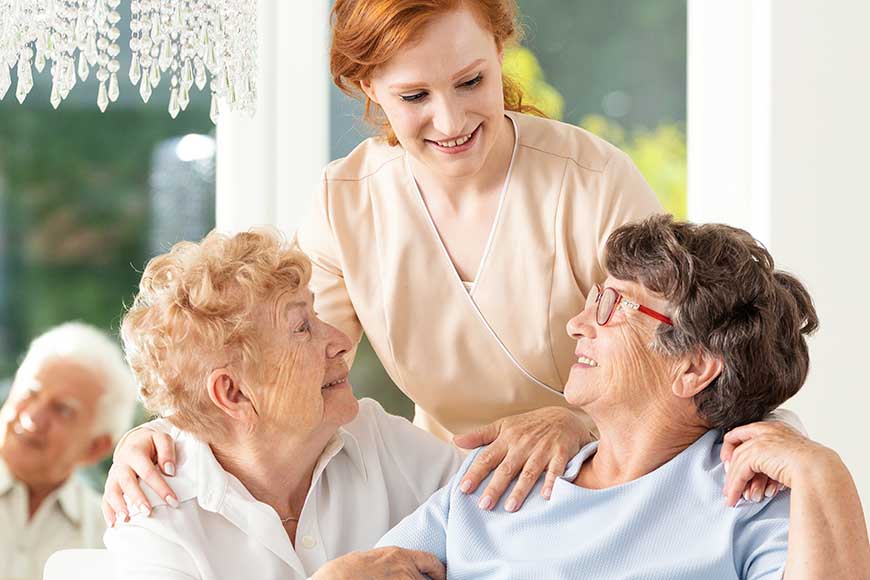Dominion of Richmond | Happy friendship in old age. Tender caregiver standing behind se
