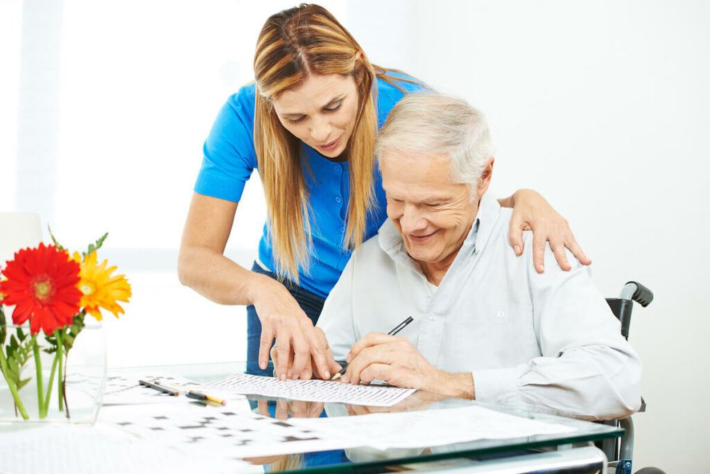 Dominion of Richmond | Senior man doing a memory care exercise with the assistance of his caregiver