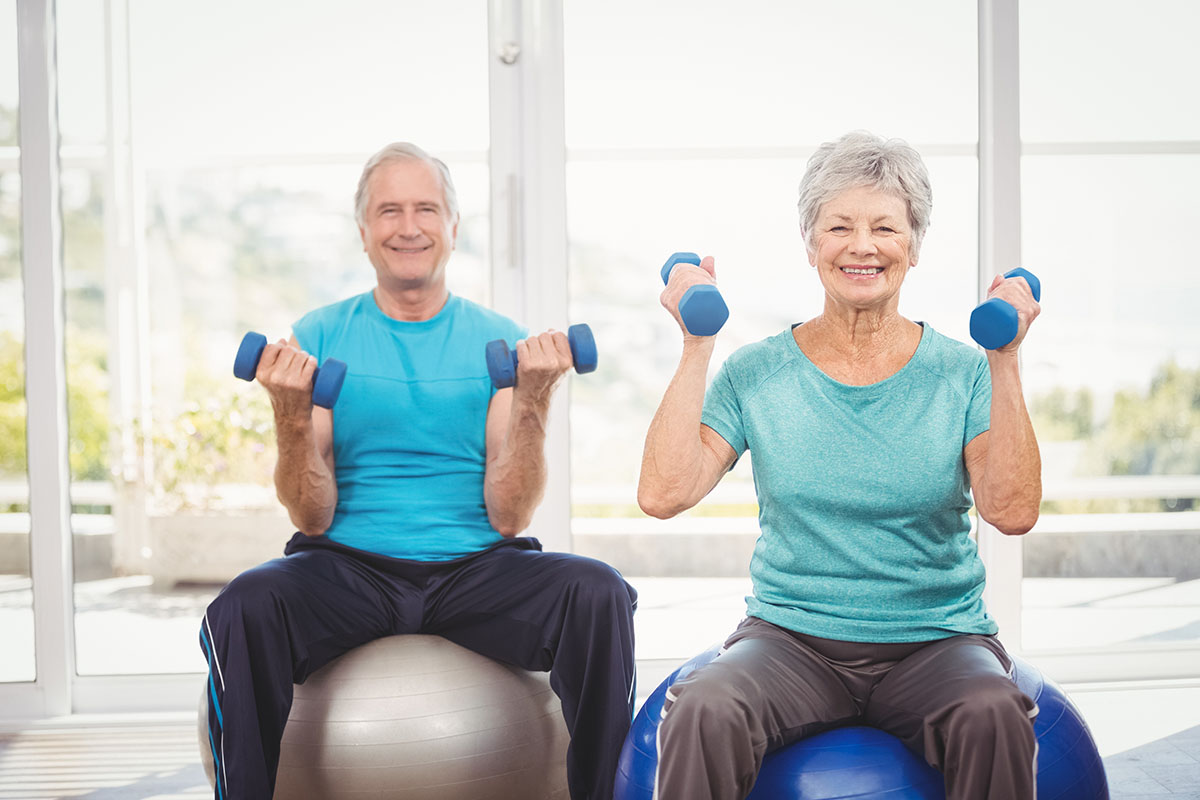 Dominion of Richmond | Portrait of smiling senior couple holding dumbbells