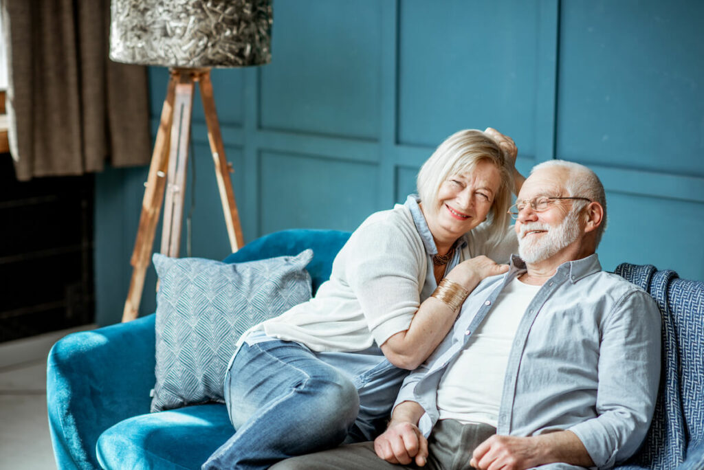 Dominion of Richmond | Senior couple sitting on the couch smiling at each other