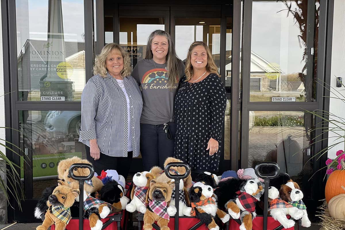 Dominion of Richmond | Three women smiling posing in front of a crate of stuffed animals