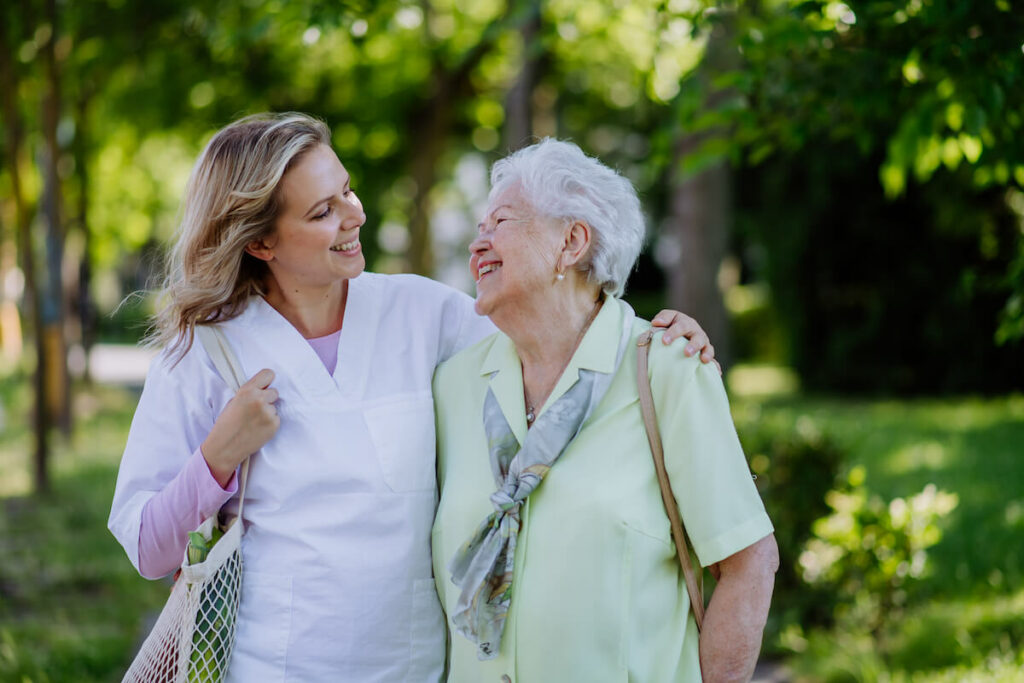 Dominion of Sevierville | Caregiver and a senior woman holding shopping bags and smiling