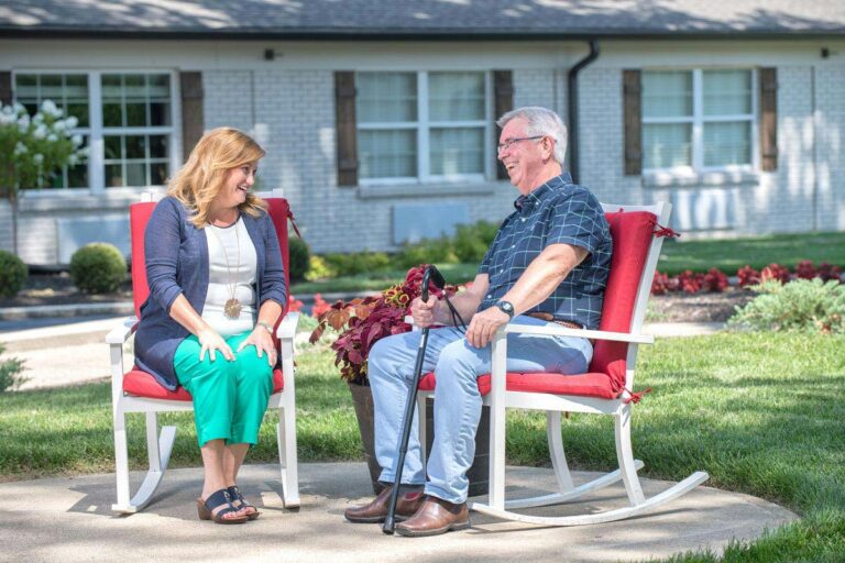 Dominion Senior Living | Senior man sitting with associate outdoors