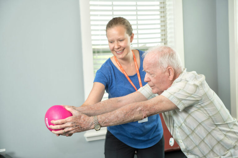 Dominion Senior Living | Associate helping resident exercise