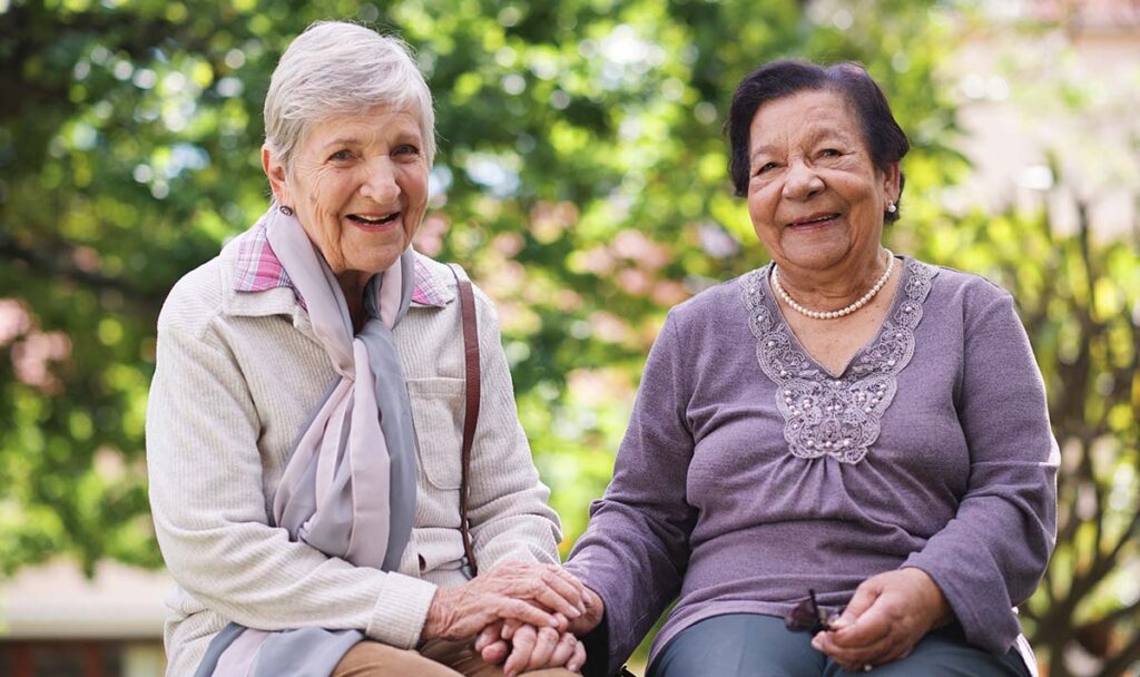 Dominion of Frankfort | Two happy senior woman sitting on a bench in the park